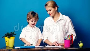 年轻的女人带着一个用彩色铅笔画的小男孩，在蓝色的背景上进行<strong>情感交流</strong>。 妈妈和儿子